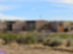 A sleek modern building set in the scrubby desert.