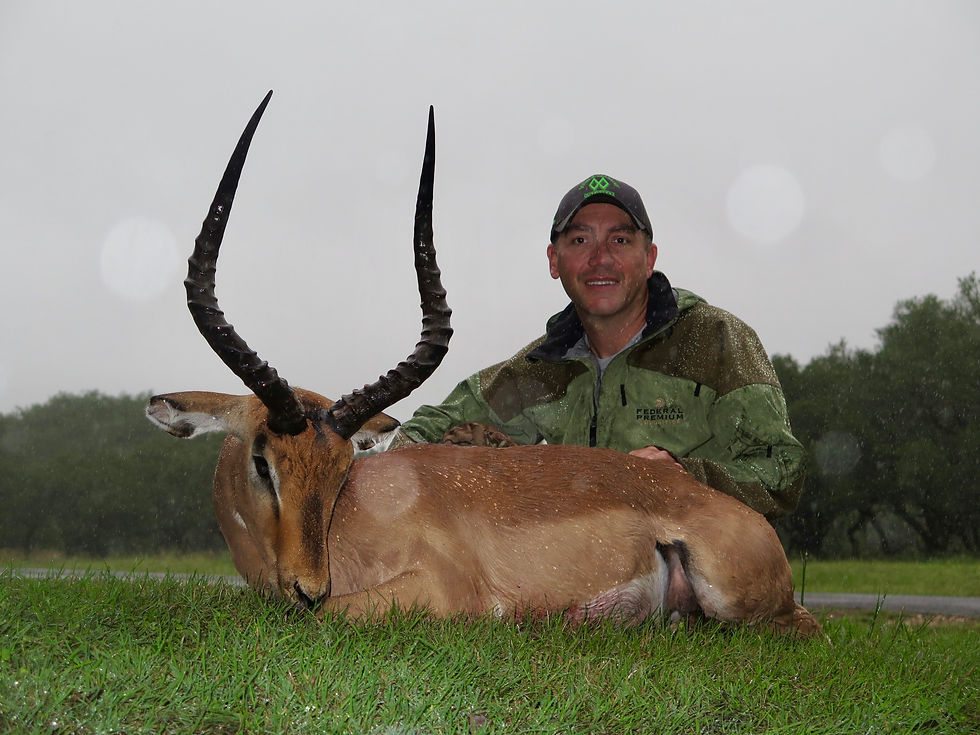 Wes Mundy kneeling next to his trophy Impala antelope