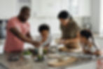 A family at standing at a kitchen island putting lunches together