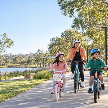mum 2 children on bikes in park_chatgpt_spring_schoolholidays.png