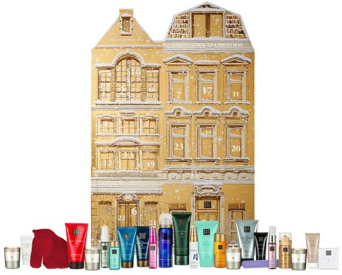 The Rituals advent calendar looks like a gold townhouse and is at the back of the photo against a white background with the product all laid out in front of it.