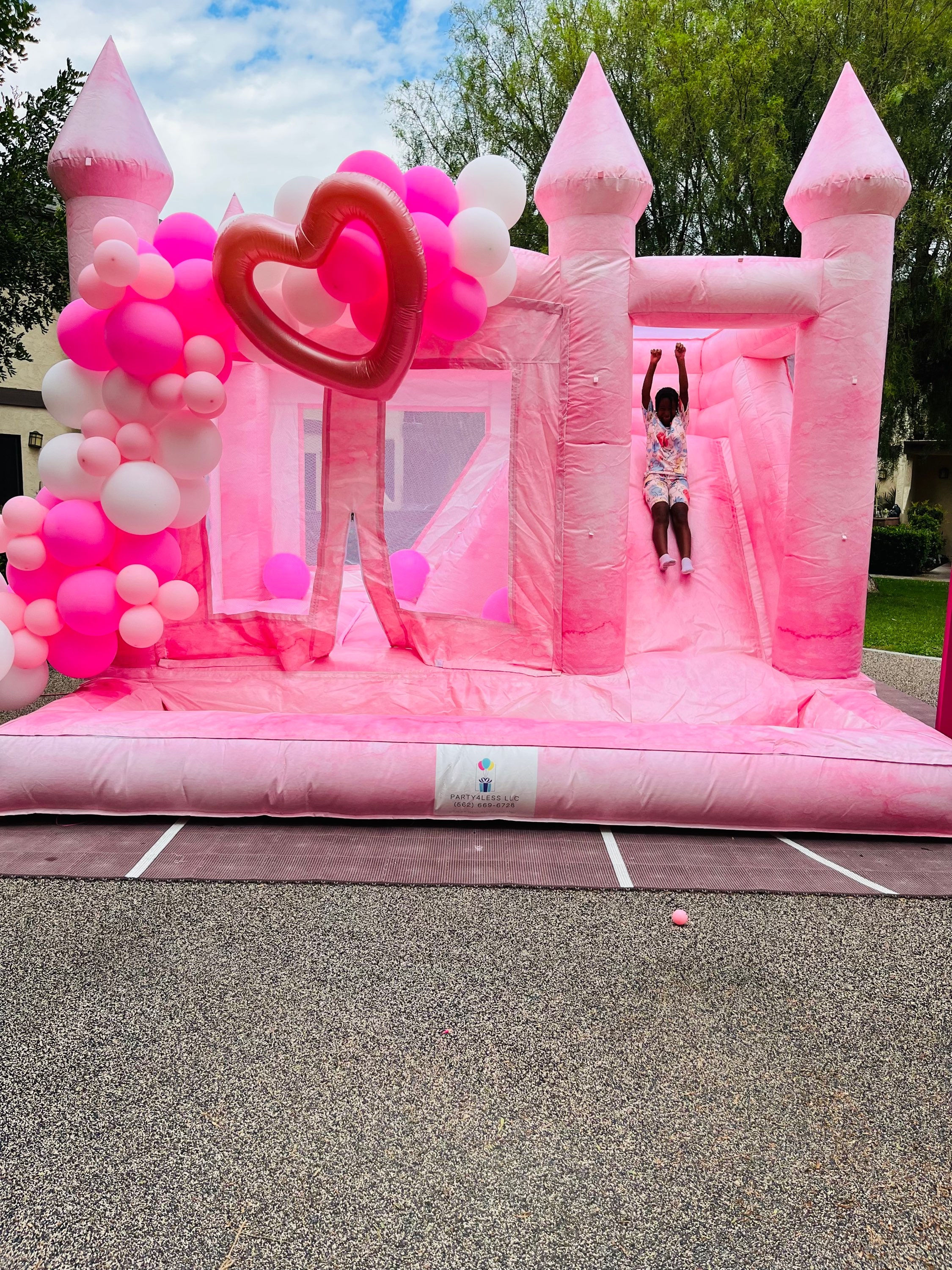 Pink and white tie-dye bounce house with slide and ball pit 