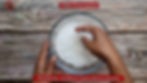 Tapioca Khichdi - Method 5 -Fluffing up soaked sabudana with fingers in a bowl on a wooden surface.