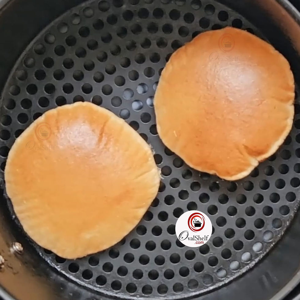Two golden-brown puffed Air Fryer Pooris in an Air Fryer basket creating a warm and inviting mood.