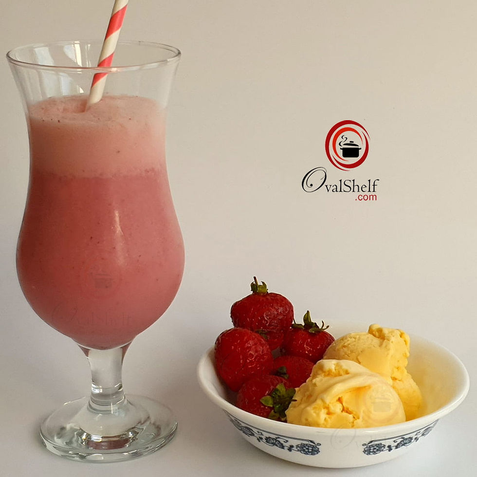 A pink strawberry milkshake with a striped straw in a glass. A bowl of strawberries and vanilla ice cream sits nearby.
