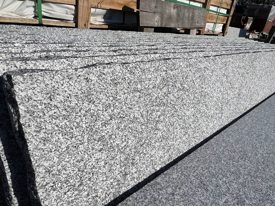 Thumbnail: A close up of granite stair treads. The granite is white with black flecks and it has a slip resistant surface.