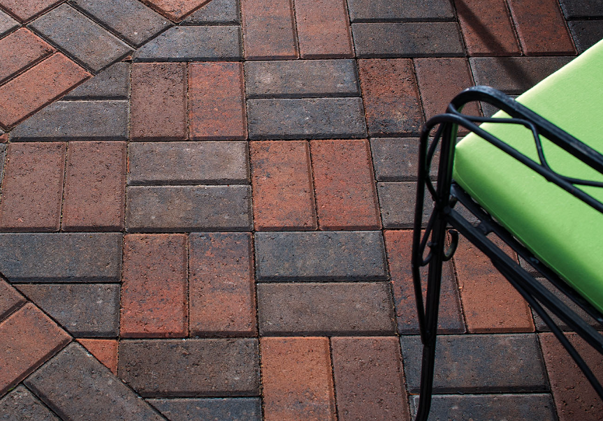 Thumbnail: A close up of a small outdoor patio using Belgard Holland Stone 4x8 paver in a red and black blend, color called Faneuil Hall
