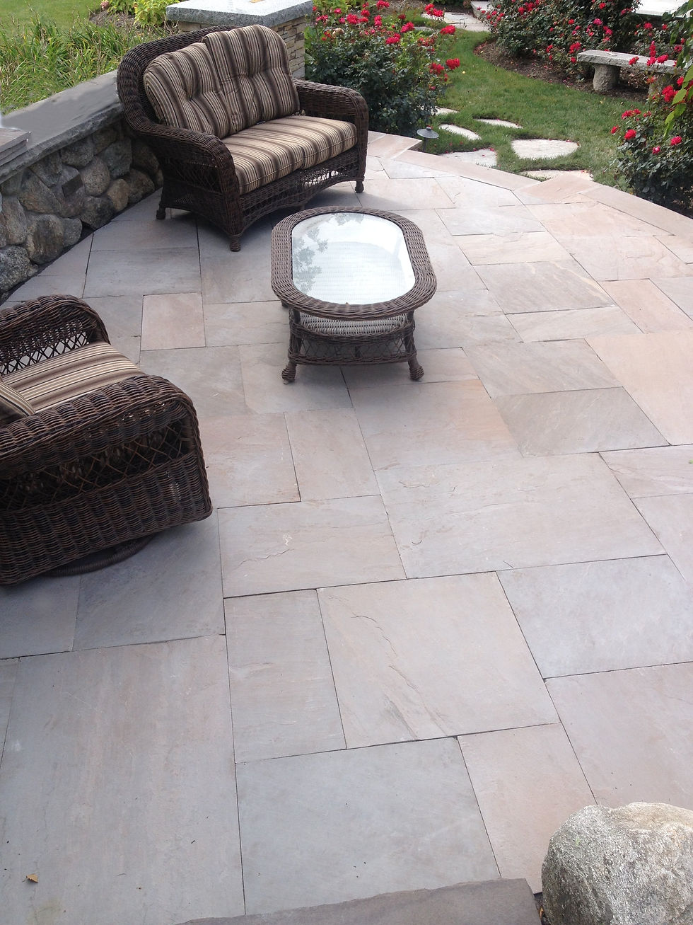 Thumbnail: An outdoor patio with two lounge chairs and a table. The patio is made of purple, red, and brown pieces of natural sandstone