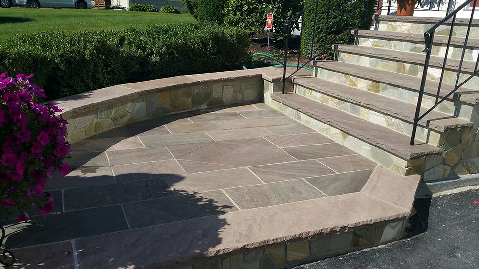 A large front walkway made of natural brownstone flagging. The pieces are an array of purple, lilac, and brown pieces.