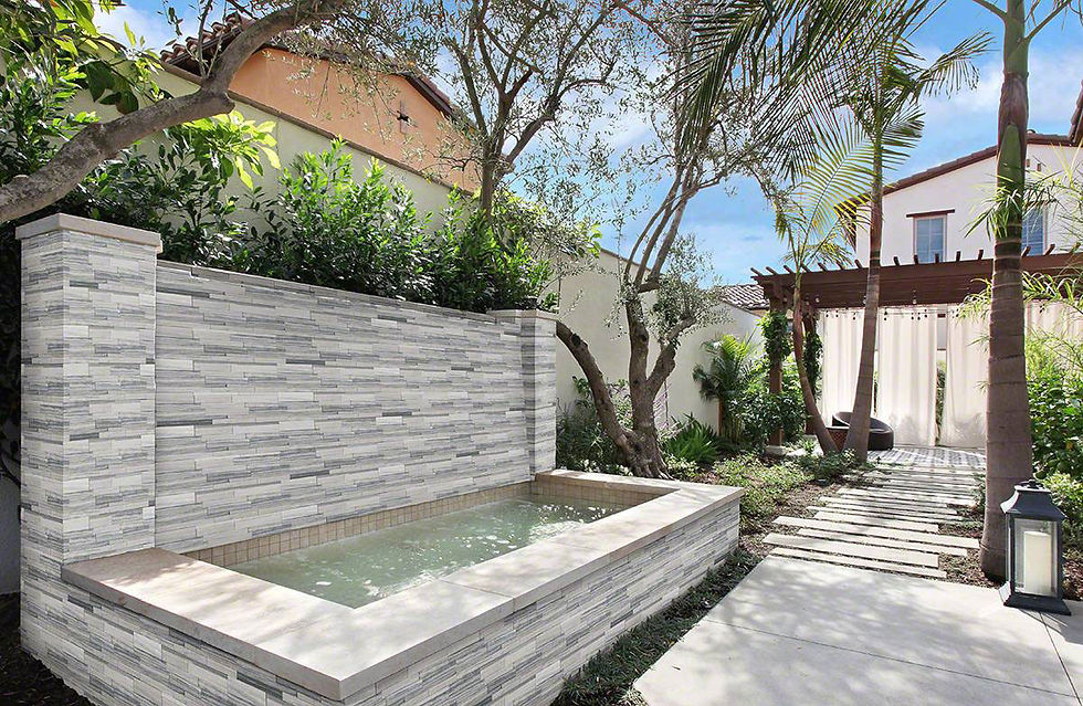 A small outdoor water fountain that is veneered in a light and dark grey blended natural stone veneer stacked panel