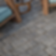 A close up of an outdoor patio using Belgard Charlestone paver which have a tumbled look like granite cobblestones