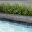 Thumbnail: A close up of the Terrazzo bullnose pool coping in black. Behind the coping is a row of Aztec grass.