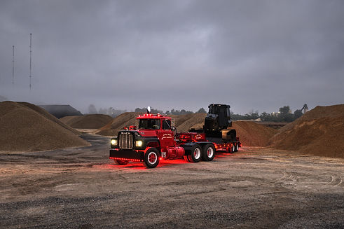 Red Mack truck hauling equipment