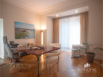 Stanze ampie e luminose nell'ufficio di lusso ai Parioli, Roma, con soffitti alti, finiture di pregio e pavimenti in parquet.