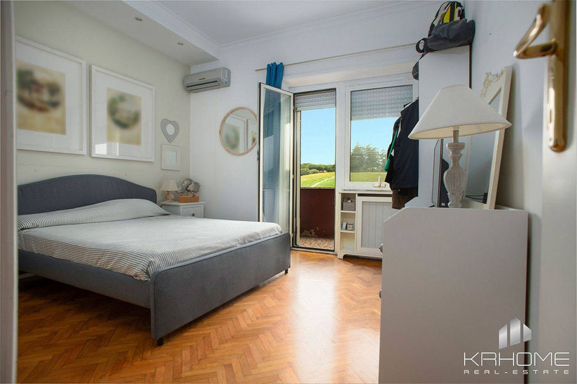 Spaziosa camera matrimoniale con vista sul verde, nell'appartamento di pregio adiacente a Villa Pamphili, Roma.