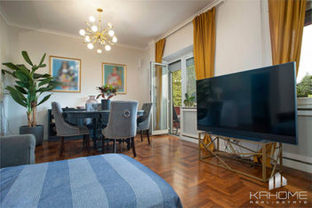 Salotto ampio e luminoso con zona pranzo, nell'appartamento a Villa Pamphili, Roma, con accesso a un grande balcone affacciato sul verde.