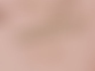 Gold capsules scattered on a pink background with Scrabble tiles spelling "CANNABIS." Soft lighting casts subtle shadows.