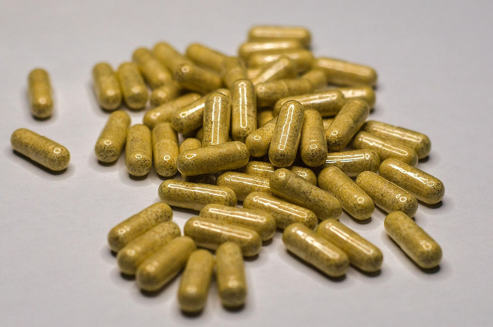 Yellow capsules scattered on a white surface, reflecting light. No text or additional objects, creating a focused, clinical feel.