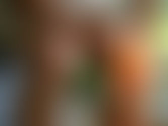 Person holds a painful knee with glowing red bones, indicating discomfort. They're seated on a sofa with plants visible in the background.