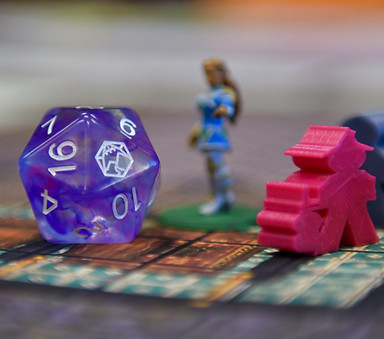A 20-sided die next to some D&D miniatures.