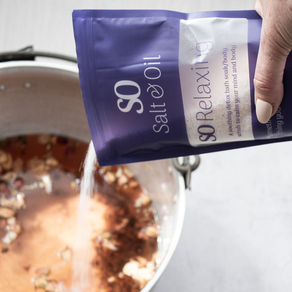 Thumbnail: pouring relaxing bath soak into a tub of warm water with petals as luxurious foot soak spa