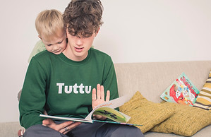 Lastenhoitaja ja pieni lapsi lukevat kirjaa Suomessa.