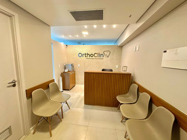 Recepcionista da Orthoclin cumprimentando paciente com sorriso e cordialidade
