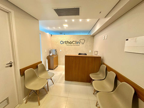 Recepcionista da Orthoclin cumprimentando paciente com sorriso e cordialidade