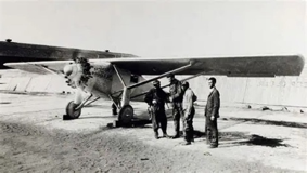 Lindbergh beside his plane with other men
