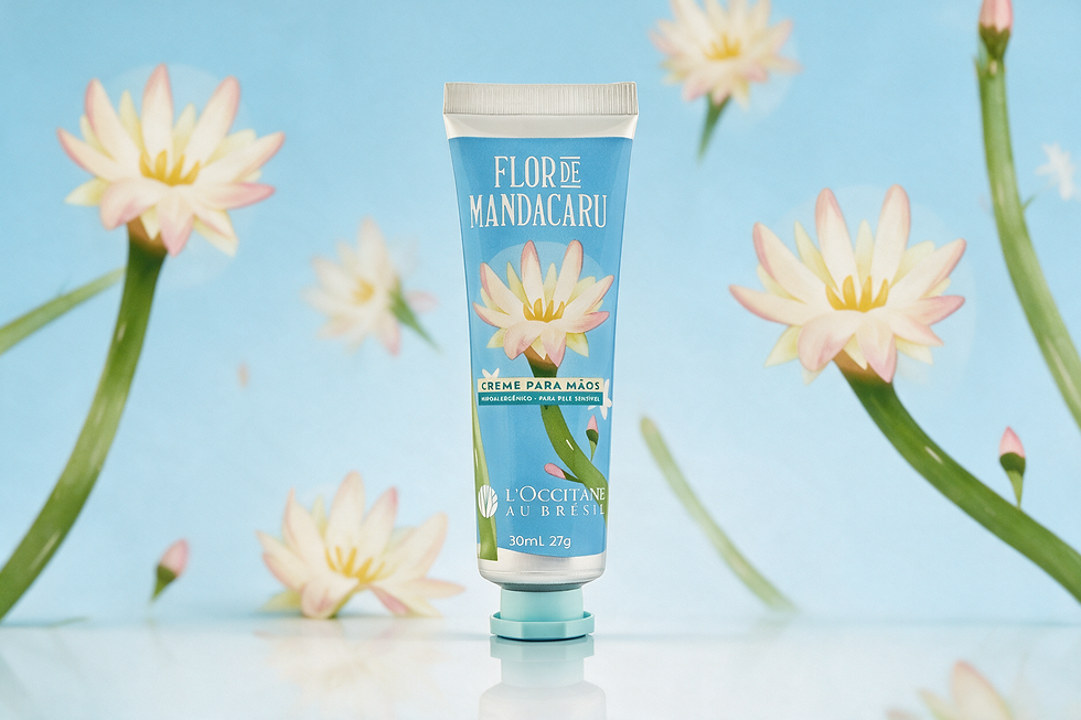 Creme para mãos Flor de Mandacaru da L'Occitane au Brésil, tubo azul entre flores brancas e rosas, fundo azul suave.
