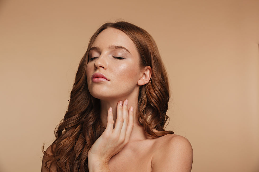 Mulher de cabelos castanhos com olhos fechados toca o pescoço, em fundo bege suave, com expressão serena.
