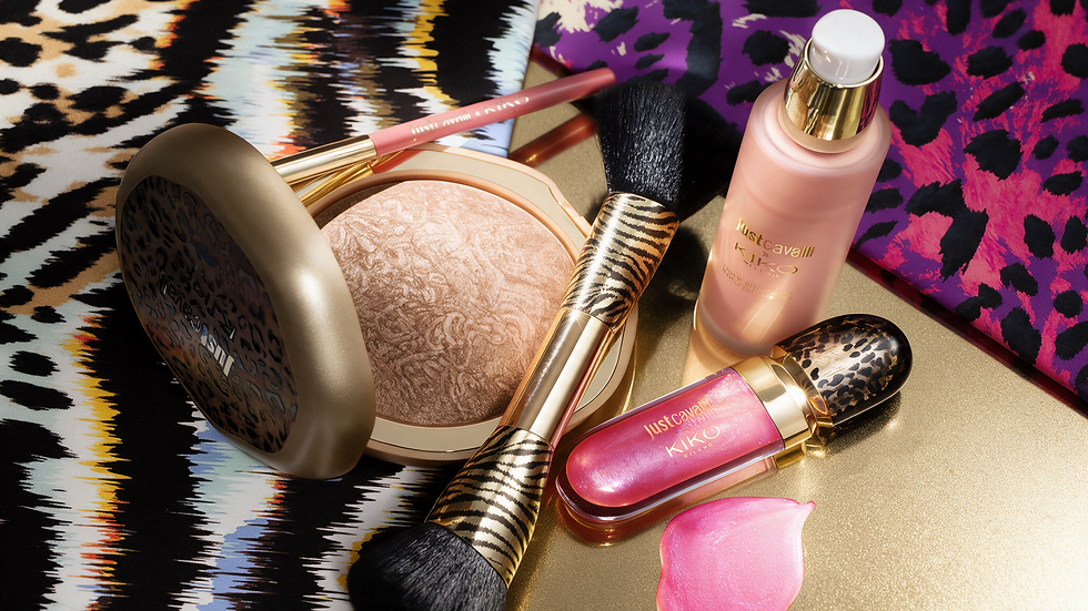 Produtos de maquiagem KIKO e Just Cavalli sobre fundo dourado, com pincéis e estampas animal print brilhantes.