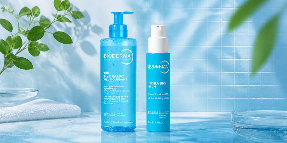 Duas embalagens azuis da Bioderma Hydrabio, Gel Moussant e Sérum, sobre bancada azul com folhas verdes e toalha branca.