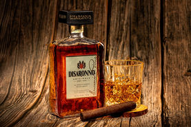 Disaronno Originale bottle styled with a drink and cigar for commercial spirits photography.