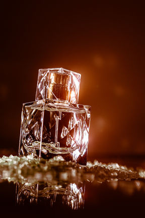 XO Khloé perfume bottle photographed with warm amber lighting and crystal textures in a luxury editorial style