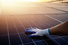 Hand mit Handschuh auf Solarmodul