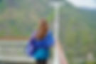 Frau mit blauem Schal blickt auf Berglandschaft.