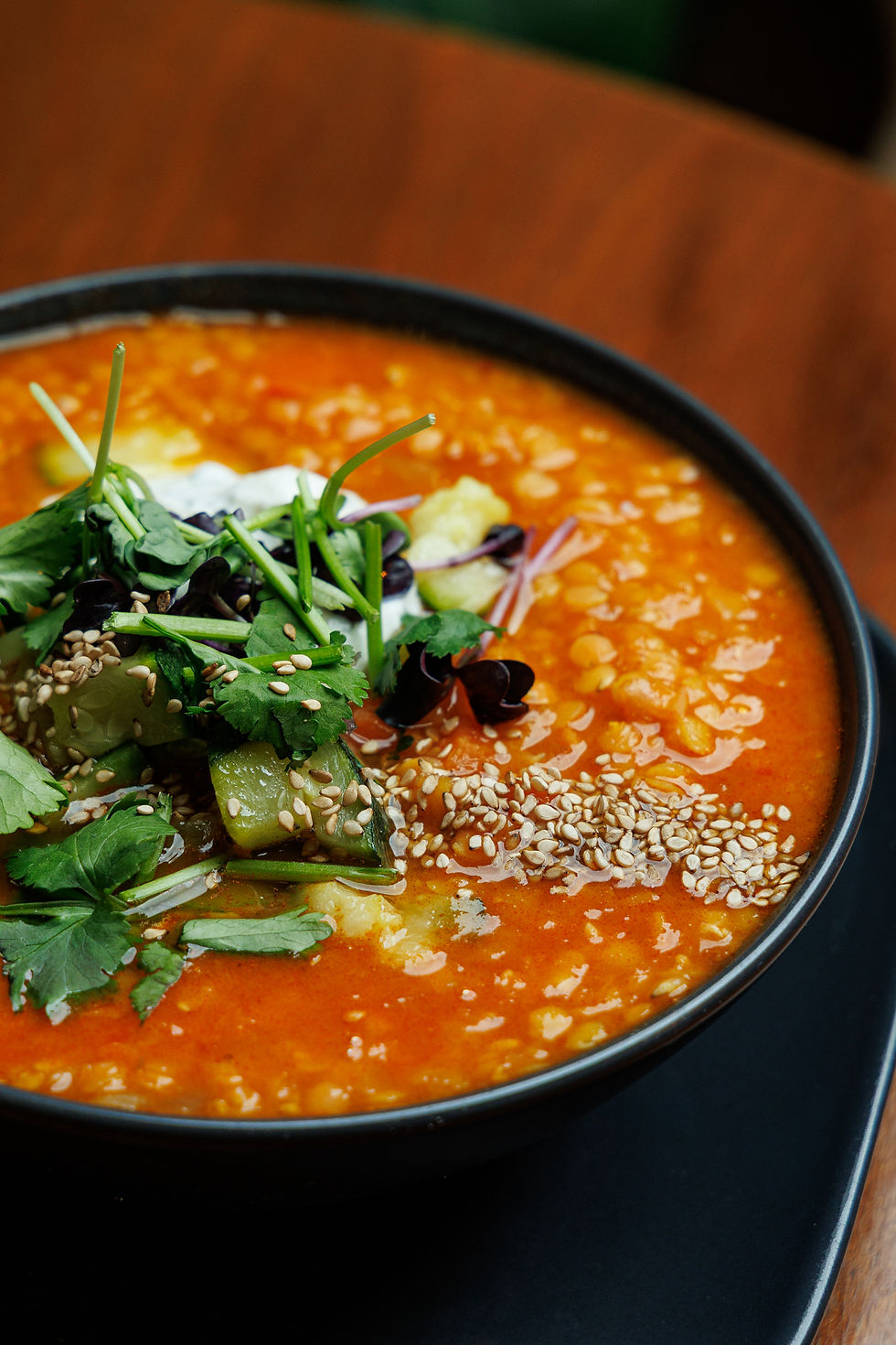 Rote Linsensuppe mit Kräutern und Sesamsamen.