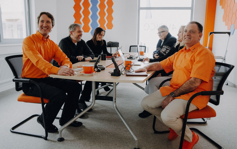 Tisch voller Mitarbeiter*innen im 4voice Büro