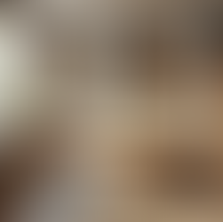 This eclectic kitchen showcases a perfect mix of materials, including concrete countertops, wooden and metal open shelving, and a wooden dining table with metal legs. The backsplash combines natural stone with patterned tiles, while modern pendant lights with vintage brass fixtures enhance the warm, welcoming ambiance.