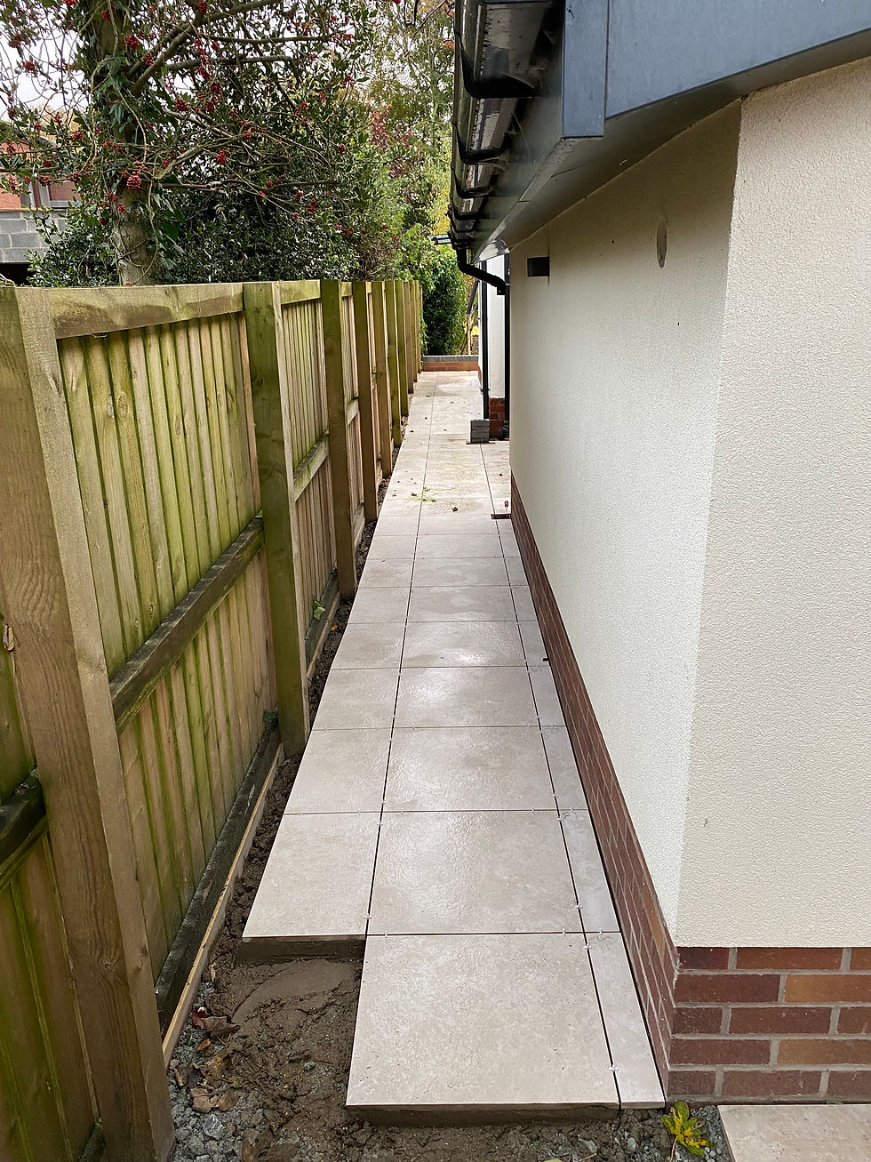 A view down the side of a house where porcelain paving has been laid.