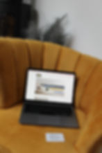 Laptop sat on a yellow chair, which contains a website Surrey Decluttering which was designed by Big Growth Marketing