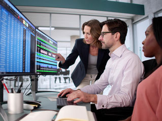 Office workers looking at data on computer screens