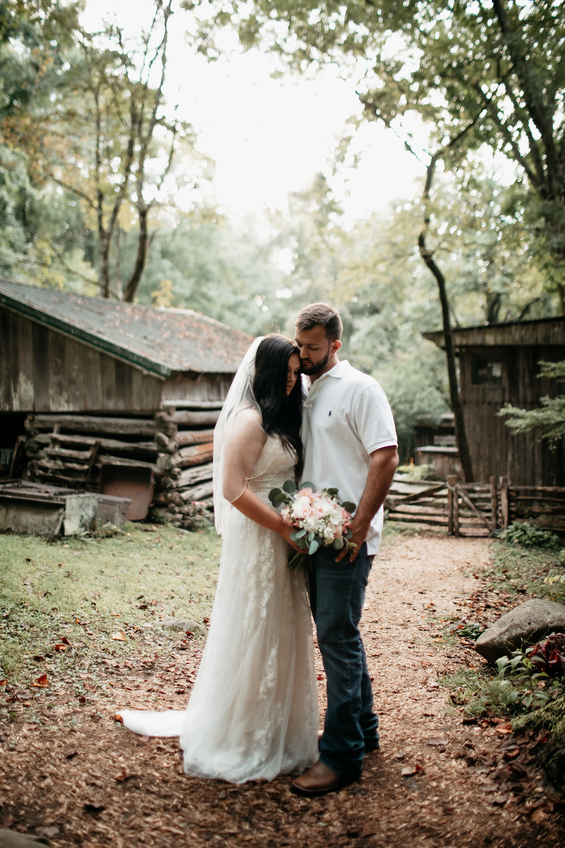 bride and groom hugging during outdoor portraits after Smokey Mountain elopement at Ely's Mill