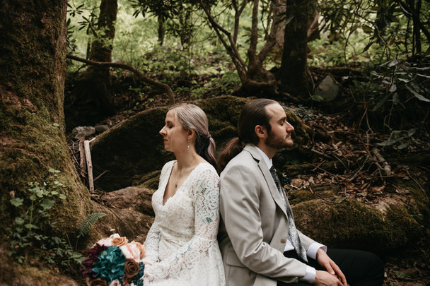 Elys Mill elopement with bride and groom sitting back to back in the woods for smoky mountain elopement 