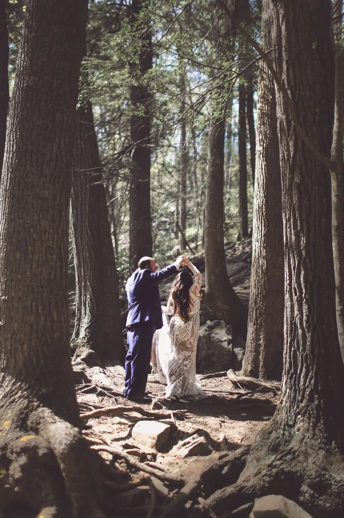 Smokey Mountain elopement photographer captures bride and groom dancing in forest by Ozone Falls after they chose to elope to Gatlinburg