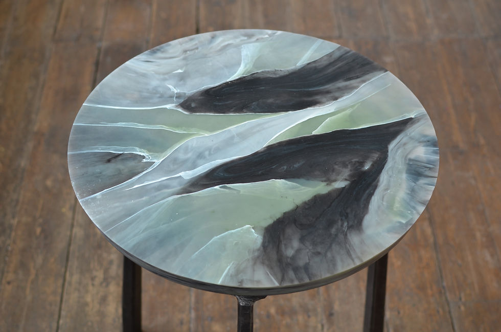 Handcrafted side table with marbled recycled plastic top and forged steel legs.