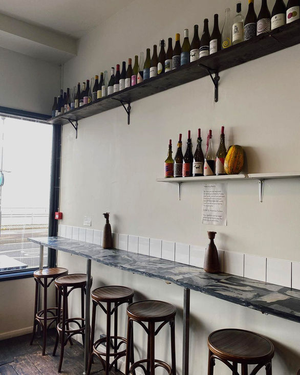 Recycled plastic bar counter with marble-effect finish paired with subway tiles and wine shelf at Angela’s restaurant, Margate UK