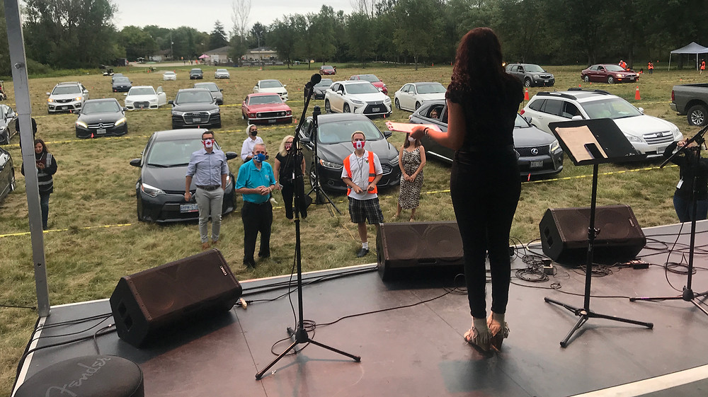Concertgoers arriving by vehicle early. Sound check in progress.