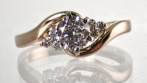 Yellow gold bypass engagement ring with white gold six-prong center setting and side diamond clusters